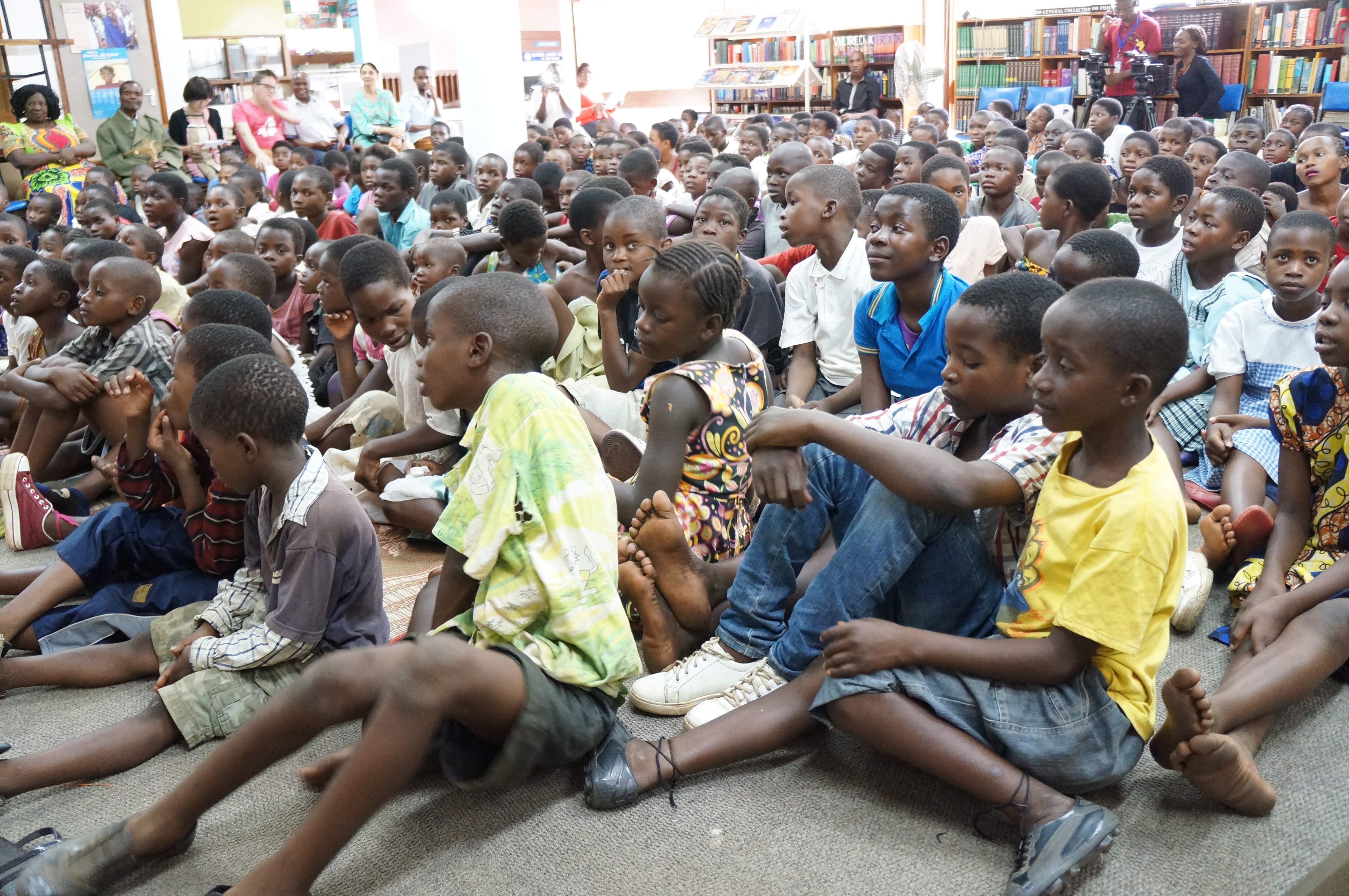 Full Image Many Malawian children sit in a library at a storytelling session