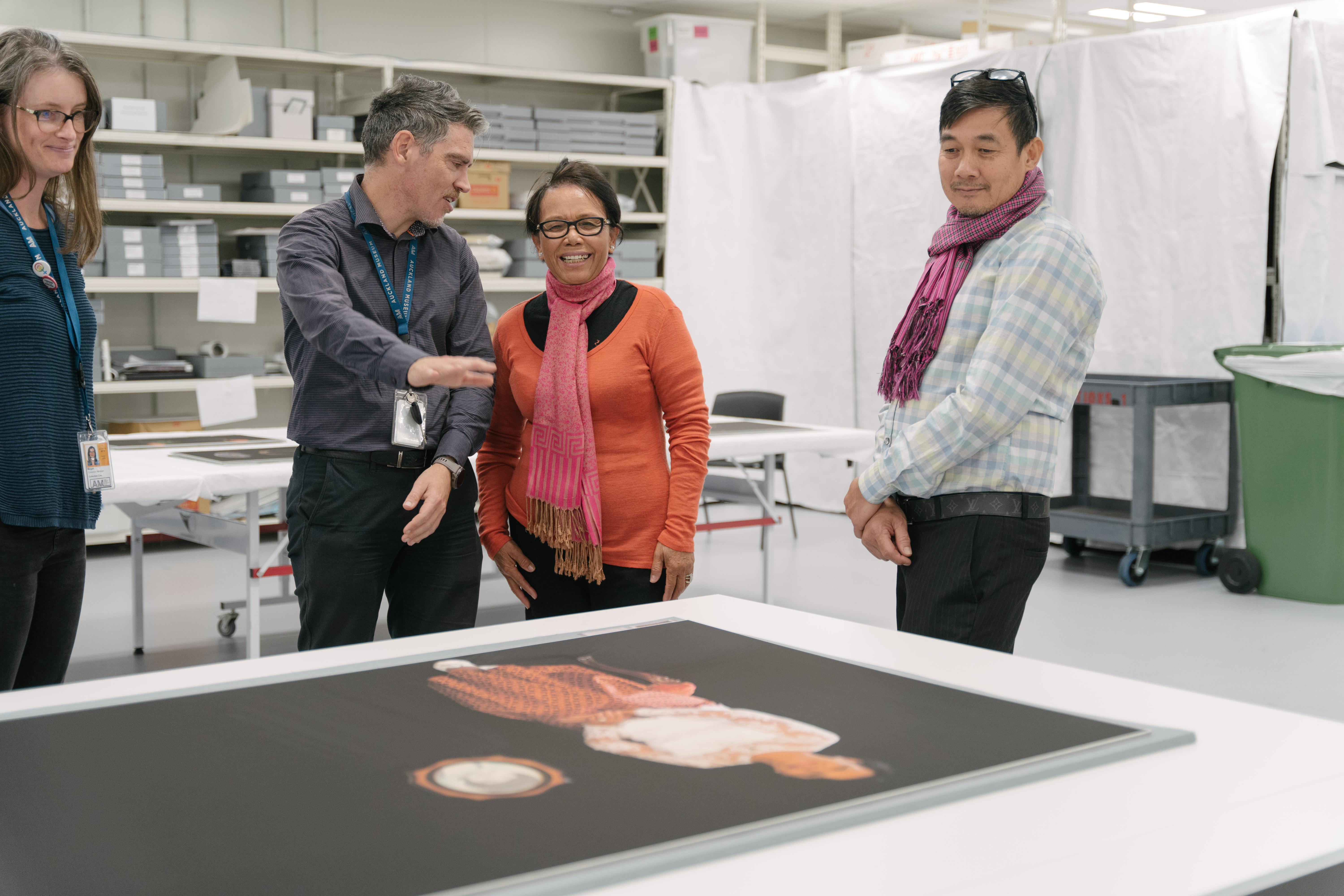 Full Image Two members of the Cambodian community and two Museum staff members view Kim Hak's works featuring one of the Cambodian community members